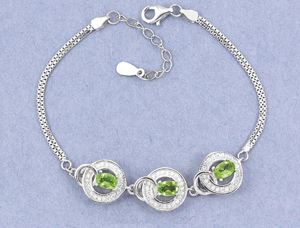 A 925 silver bracelet set with three oval cut peridots and white stones, L. 17cm.