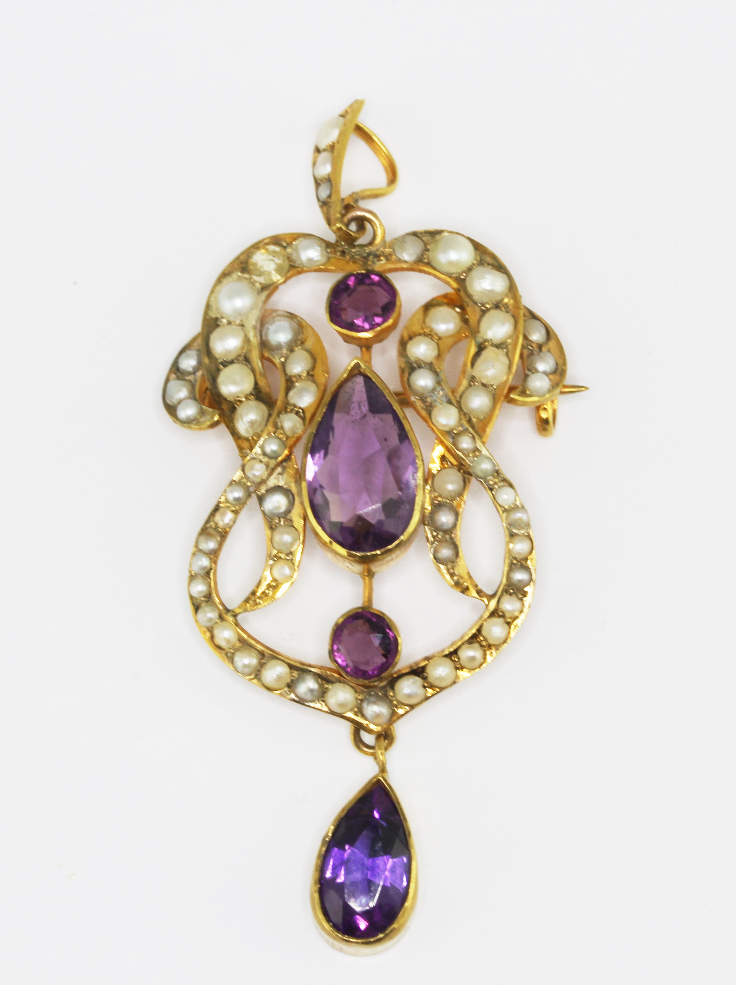 An Edwardian 9ct yellow gold (stamped 9ct) brooch / pendant set with amethysts and split pearls,