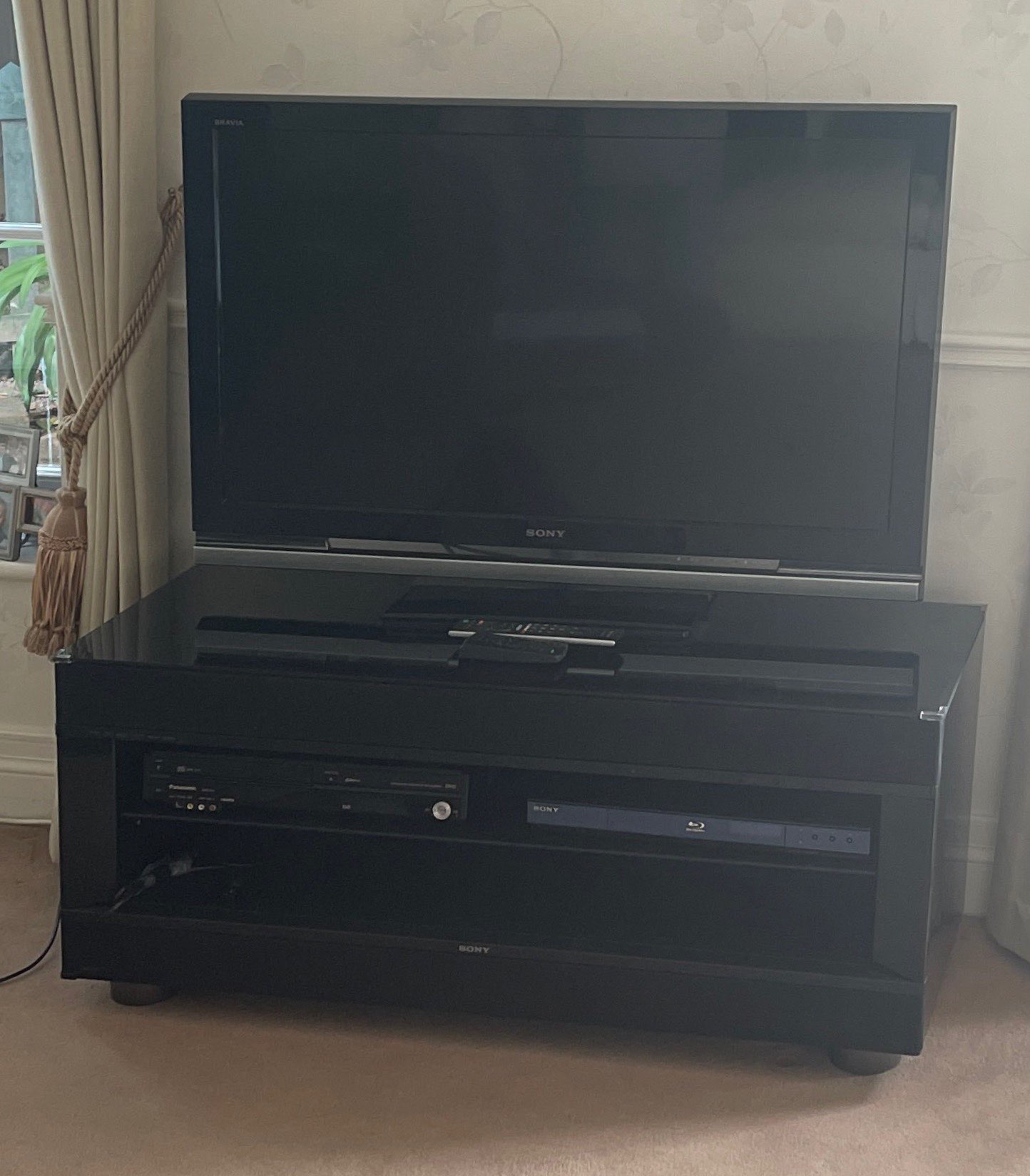 A Sony 42in flat screen television with a Sony Blu Ray disk player, Panasonic DVD player and stand