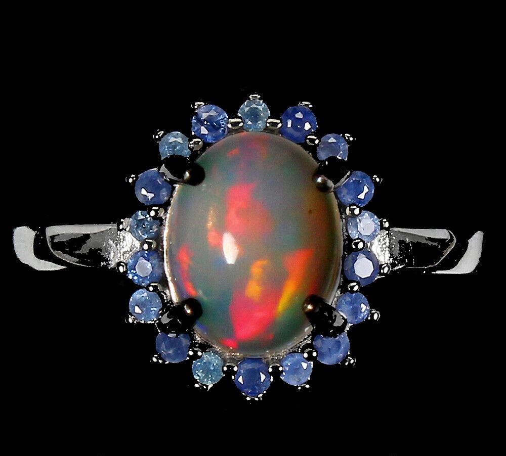 A 925 silver cluster ring set with cabochon cut opal surrounded by sapphires, (Q).