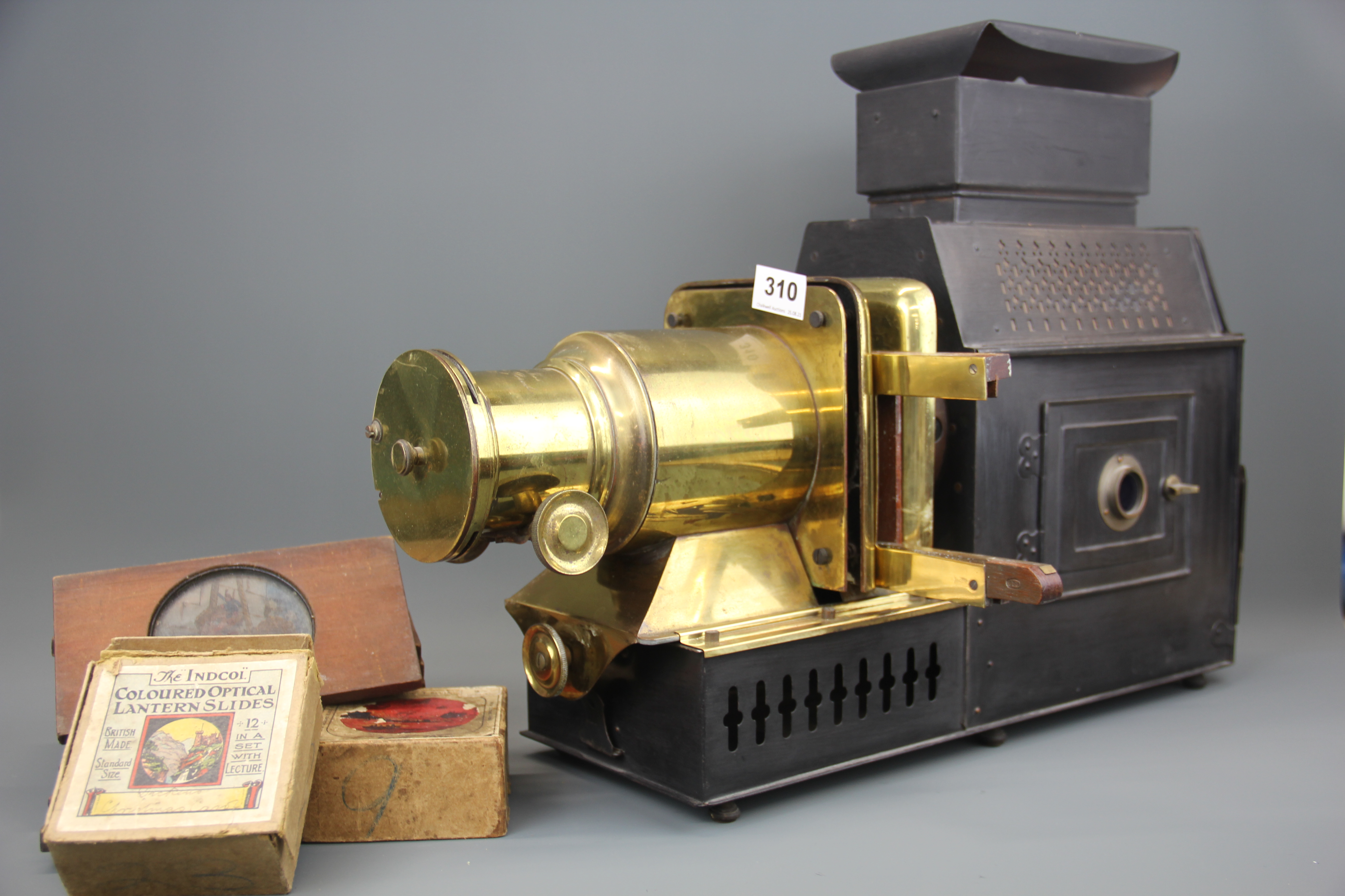 A Victorian Husband and sons brass and tin magic lantern projector with some lantern slides.