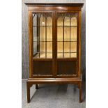 A 1920's mahogany veneered display cabinet, W. 107cm. H. 179cm.