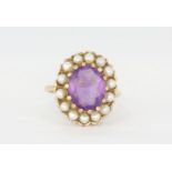 A hallmarked 9ct yellow gold ring set with an oval cut amethyst surrounded by pearls, (S).