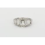 A hallmarked 18ct white gold ring set with a centre emerald cut diamond (approx 2ct) with further