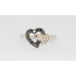 A white gold heart shaped ring set with diamonds and black diamonds, (I).