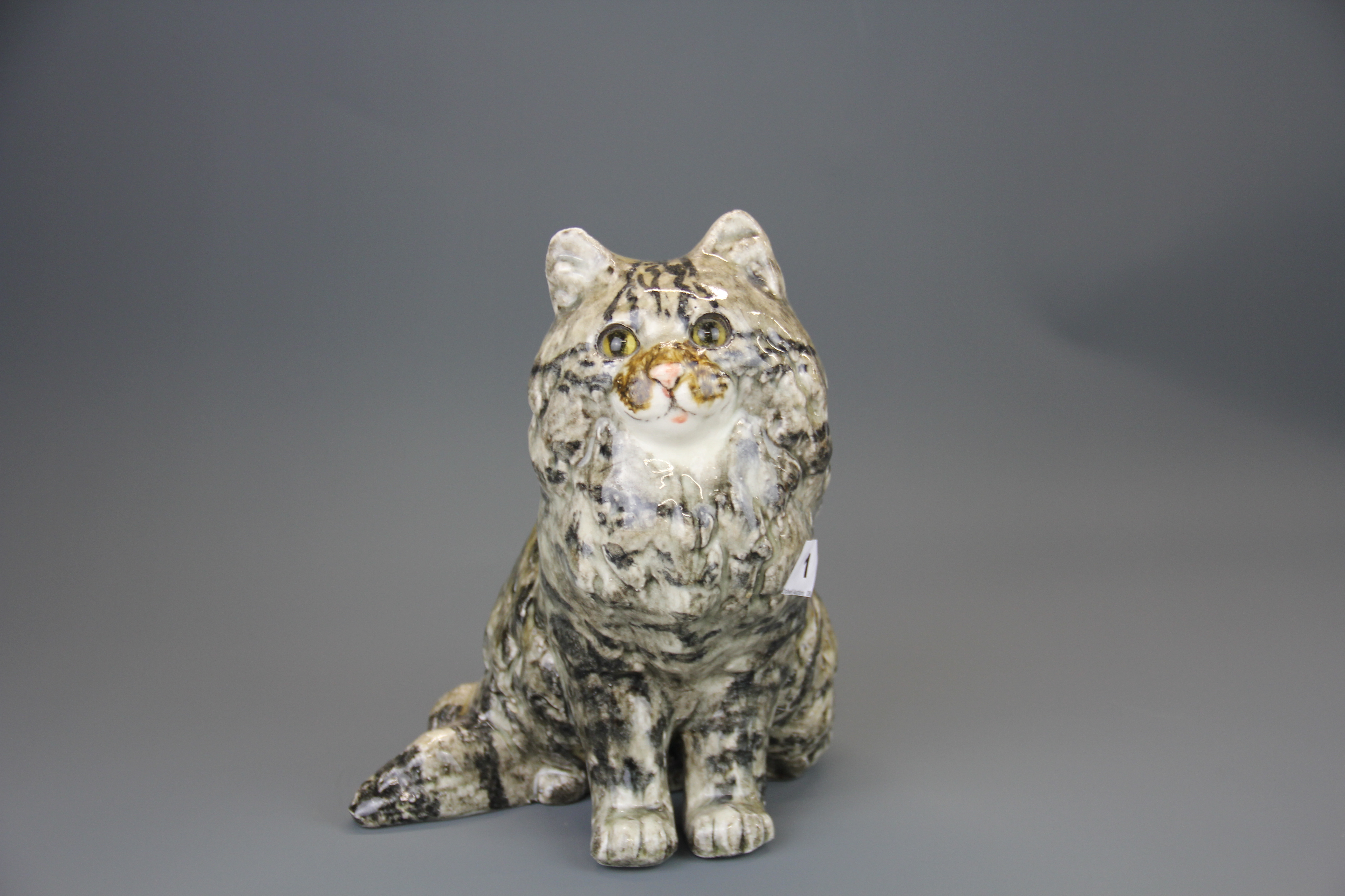 A Winstanley ceramic cat figure with glass eyes, H. 24cm.