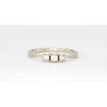 A 9ct white gold ring set with three princess cut diamonds, (P).