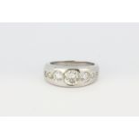 A white metal (tested 18ct gold) ring set with seven graduated brilliant cut diamonds, approx. 1.