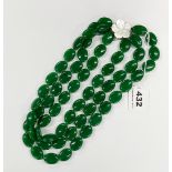 An impressive necklace of carved apple green jade/hardstone beads on a mother of pearl clasp,