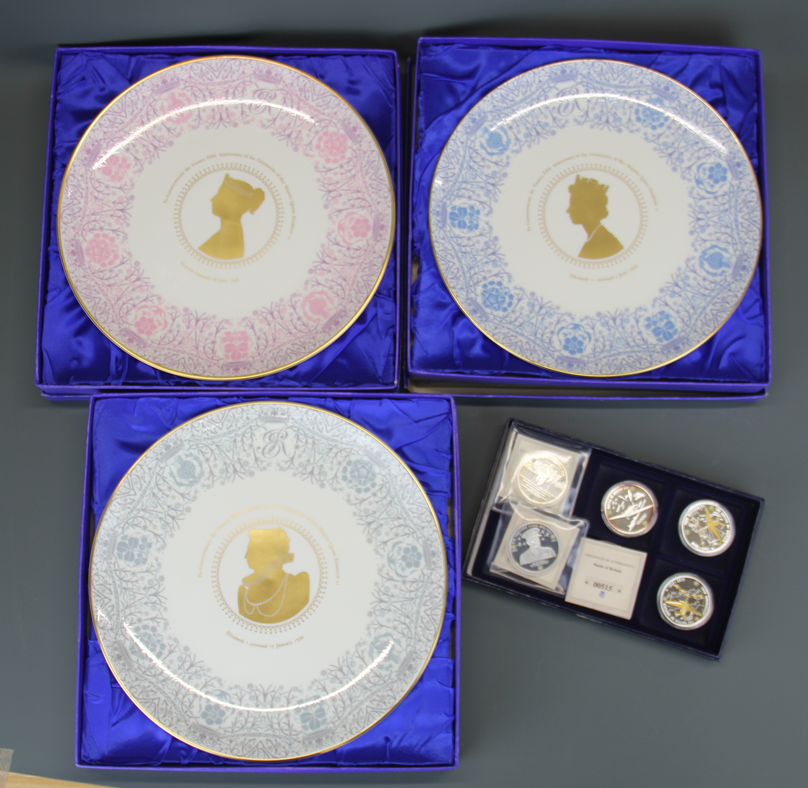 Three boxed Coalport commerative plates and a group of six Battle of Britain commerative coins.