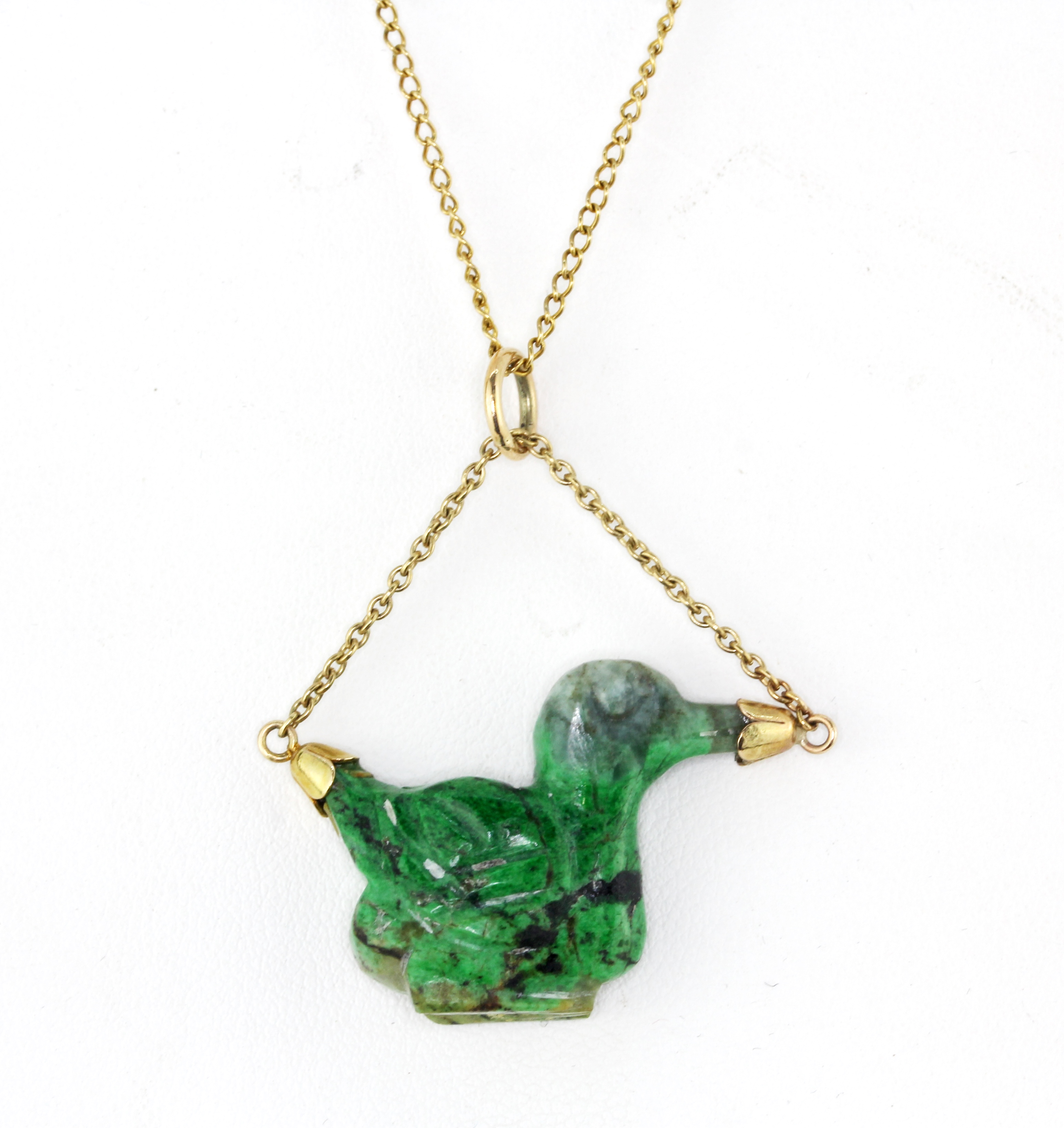 A 9ct yellow gold necklace set with a carved jade/hardstone duck shaped pendant.