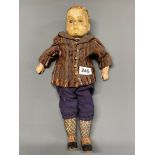 An early 20th C composition doll with glass eyes and original clothes and shoes, understood to
