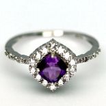 A 925 silver cluster ring set with a cushion cut amethyst and white stones, (S).