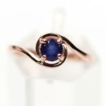 A 925 silver rose gold gilt solitaire ring set with a sapphire, (M).