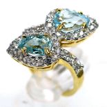 A 925 silver gilt crossover ring set with trillion cut blue topaz and white stones, (M).