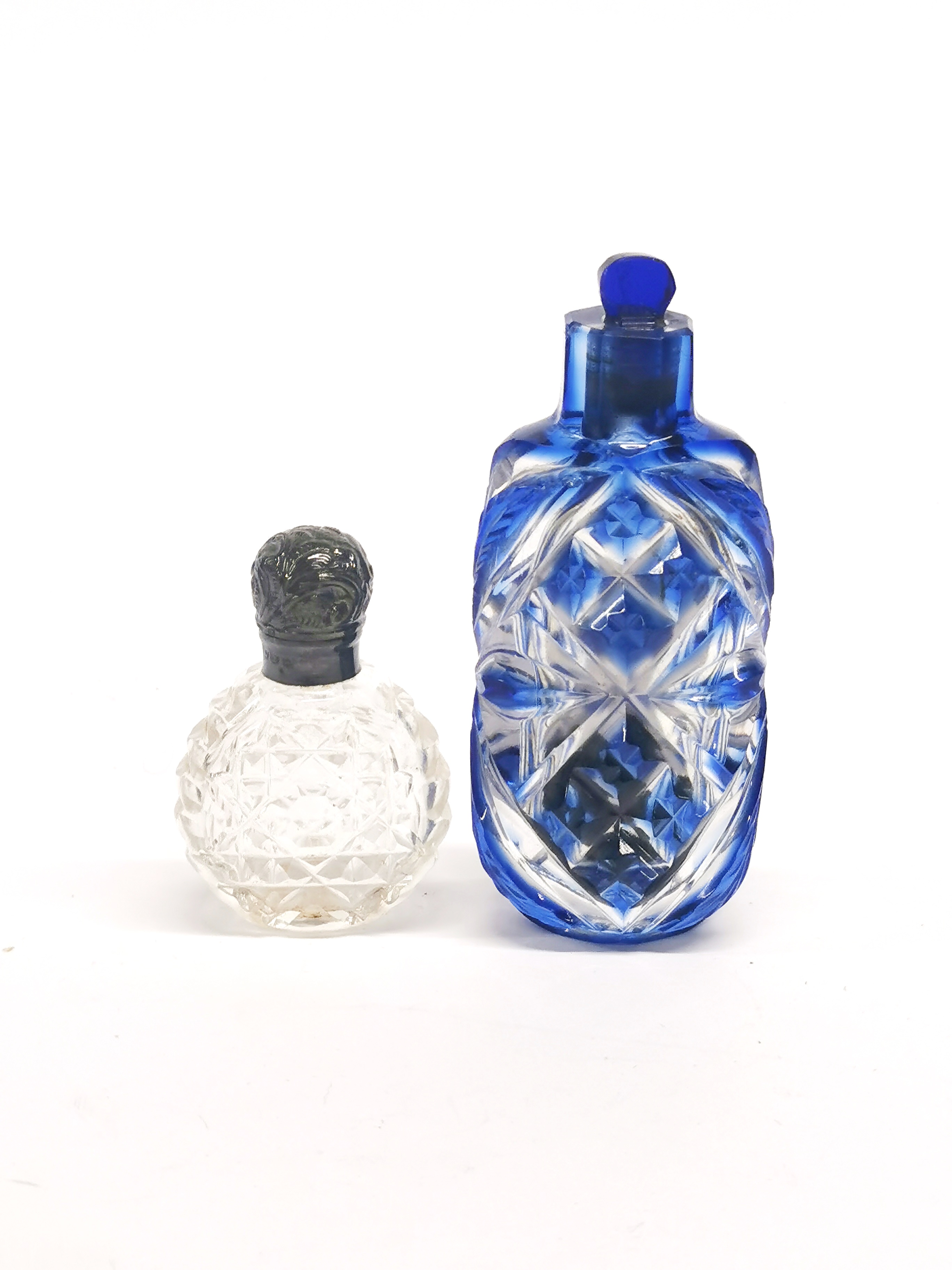 A Victorian cut glass perfume bottle and a hallmarked silver topped perfume bottle.