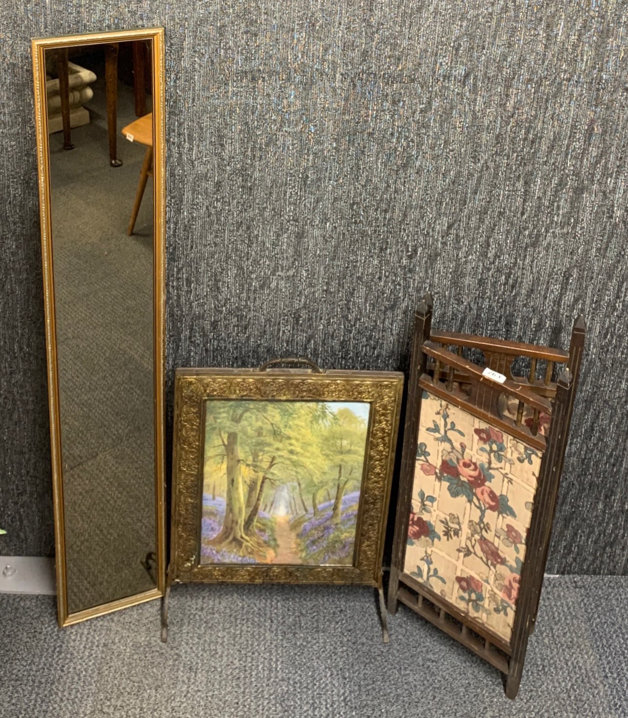 A hammered brass fire screen, a wooden fire screen (H. 81cm) and a gilt framed mirror.