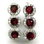 A pair of 925 silver earrings set with round cut garnets and white stones, L. 2cm.