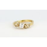 An unusual 18ct yellow gold ring set with a centre square baguette cut diamond, approx 0.5ct, with