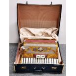 A cased Pigliacampo piano accordion.