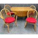 An Ercol oval drop leaf dining table, 112 x 120cm, together with four chairs, including one carver.