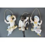 Three Victorian porcelain swinging figures, H. 14cm. Black figure is A/F.