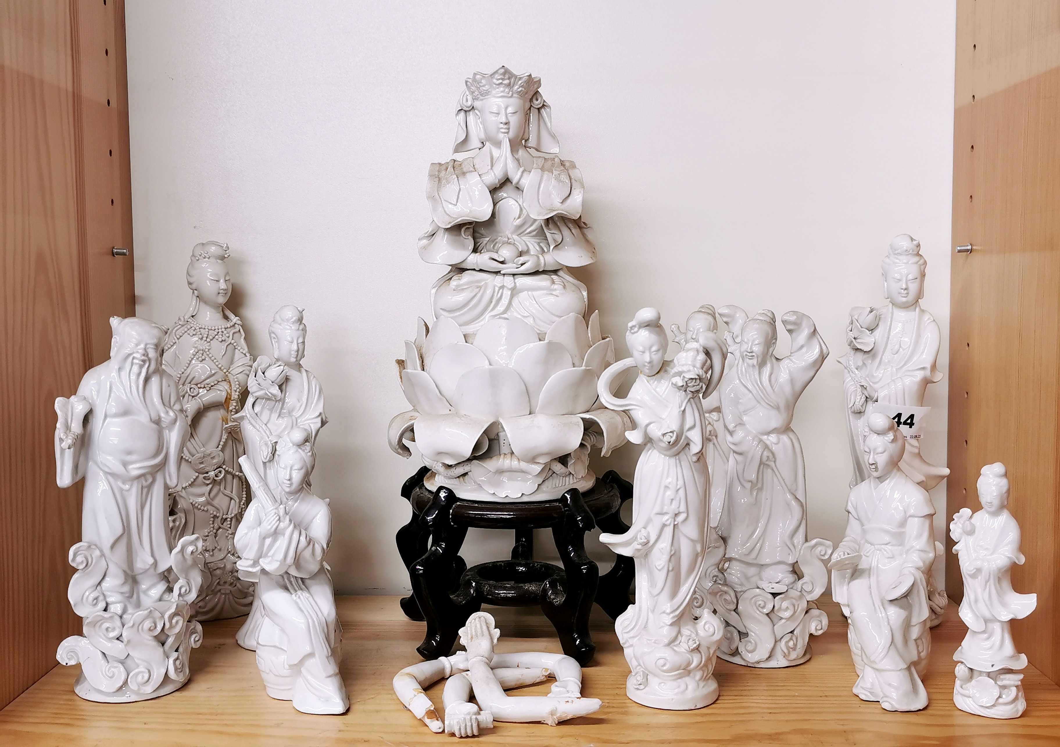 A group of Chinese Blanc de Chine porcelain figures including a deity with loose arms.