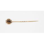 An antique yellow metal (tested minimum 9ct gold) stick pin set with a rose cut garnet, approx. L.