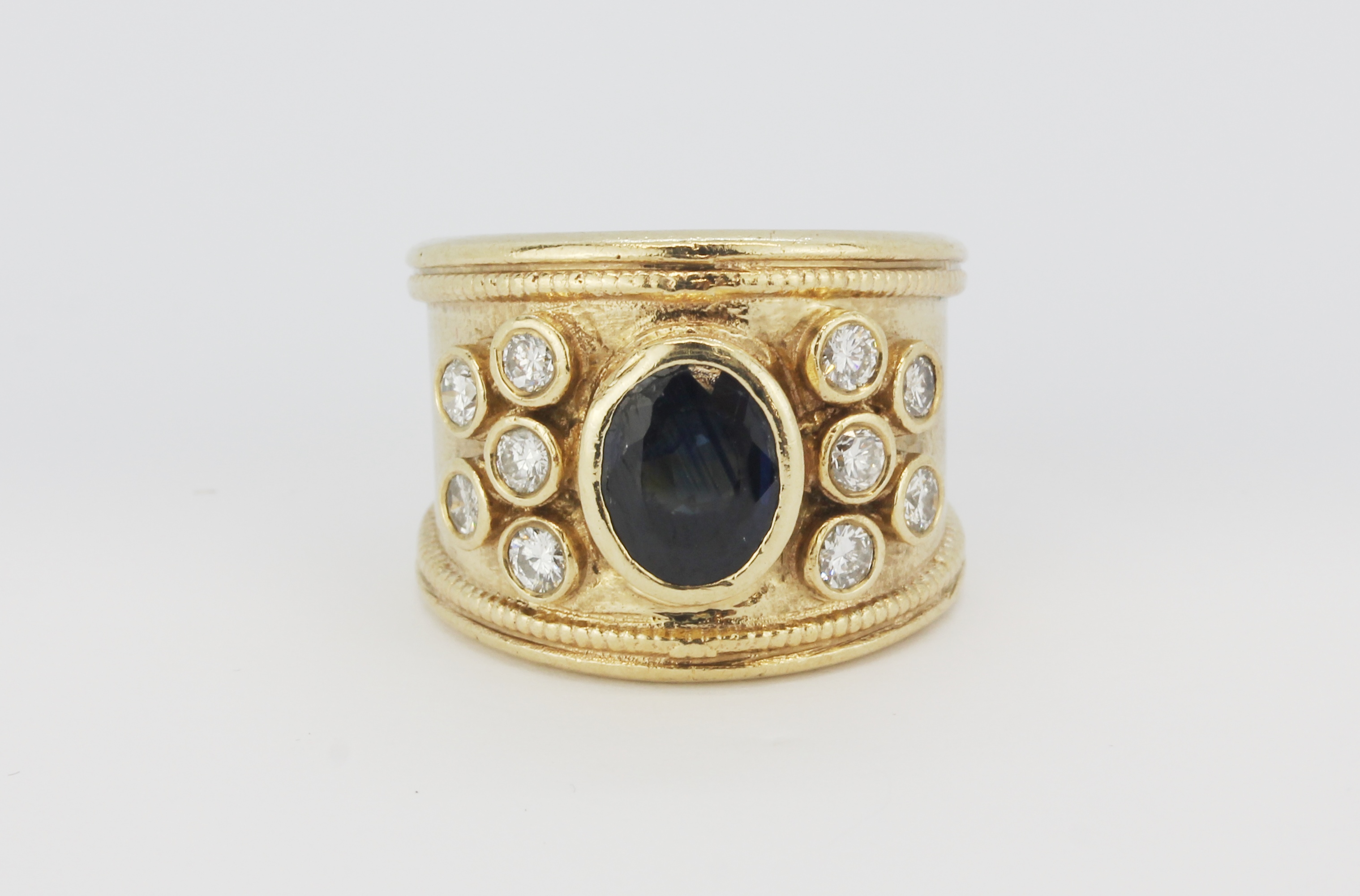 A large yellow metal (tested minimum 9ct gold) gentleman's ring set with an oval cut sapphire and