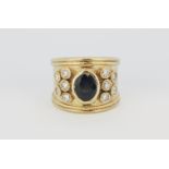 A large yellow metal (tested minimum 9ct gold) gentleman's ring set with an oval cut sapphire and