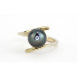 A 14ct white gold (stamped 585) ring set with a Tahitian black pearl (L).