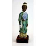 An interesting glazed oriental porcelain figure of a lady on a velvet covered wooden stand, H.