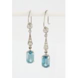 A pair of white metal (tested platinum) drop earrings set with emerald cut blue topaz and