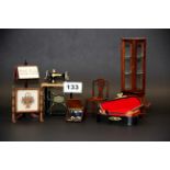 A quantity of dolls house furniture items, including sewing machine, music room items, etc.