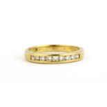 A yellow metal (tested 18ct gold) diamond set half eternity ring, (P).