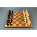 A vintage celluloid chess set with wooden board, king H. 9.5cm.