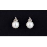 A pair of 9ct white gold pearl and diamond set stud earrings, L. 1.1cm.