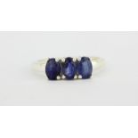 A 925 silver ring set with three oval cut sapphires, (O).