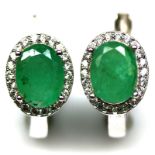 A pair of 925 silver cluster earrings set with oval cut emeralds surrounded by white stones, L. 1.