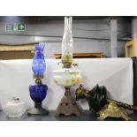 Three Victorian oil lamps and an oil lamp well, tallest 56cm.