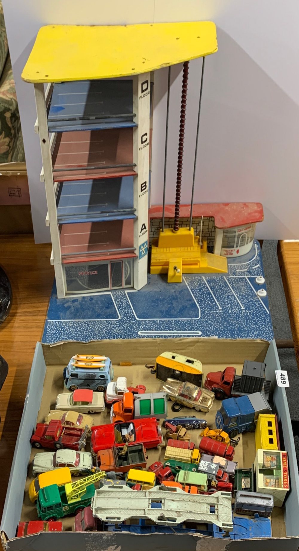 A quantity of old die cast model vehicles with a parking garage.