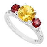 A 925 silver ring set with round cut citrine flanked by garnets, (P.5).