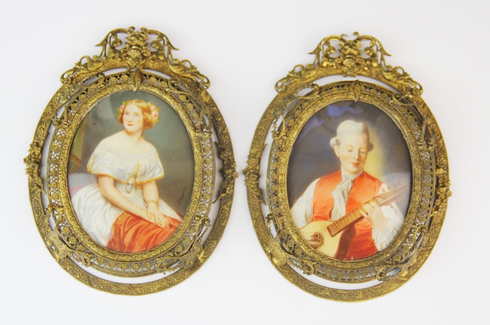 A pair of gilt framed hand painted portrait miniatures of a young woman and a musician one signed