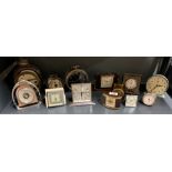 A group of mixed vintage alarm clocks and a barometer.