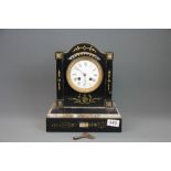 A 19th century French slate and marble mantle clock, H. 29cm.