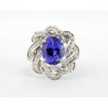 A lovely 14ct white gold ring set with a large oval cut tanzanite surrounded by brilliant cut