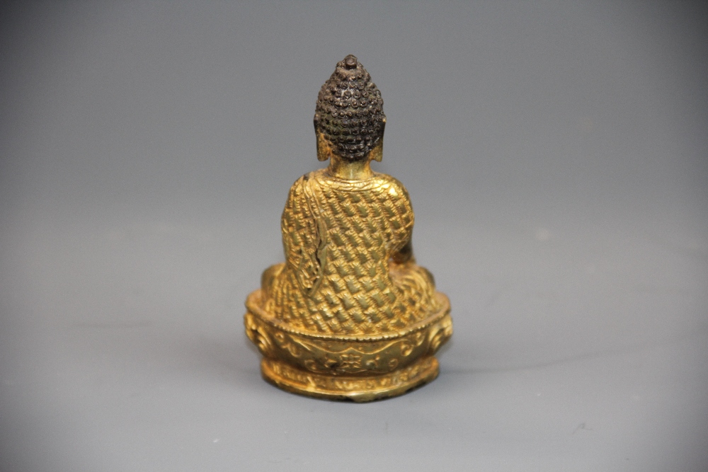 A small Sino-Tibetan gilt bronze figure of a seated Buddha, H. 10.5cm. - Image 2 of 3