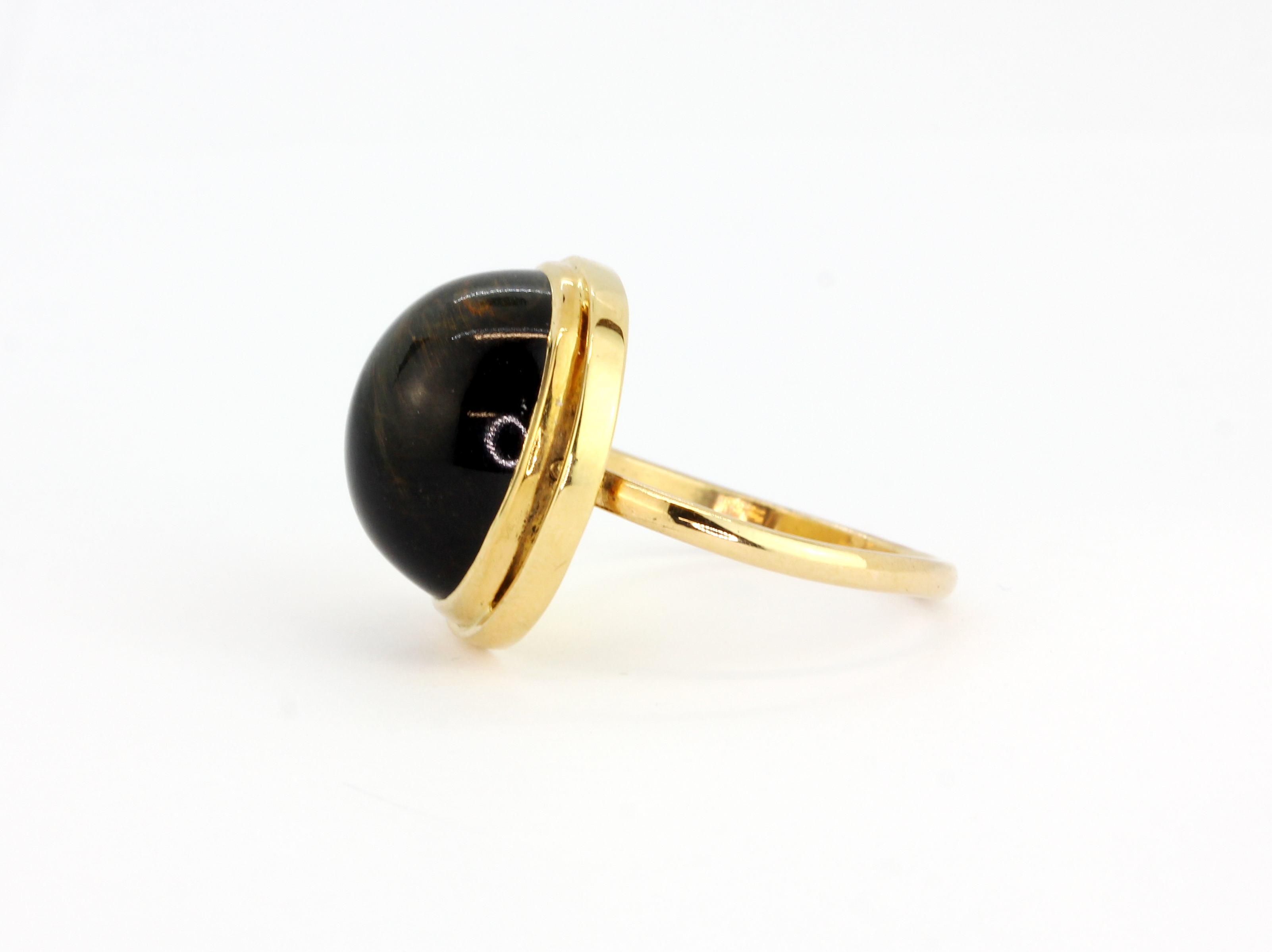 A 14ct yellow gold (stamped 14k) ring set with a cabochon cut black tiger's eye, (P). - Image 2 of 2