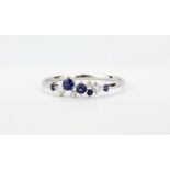 An 18ct white gold ring set with brilliant cut diamonds and sapphires, (P.5).