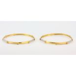 A pair of hallmarked 22ct yellow and white gold bangles, Dia. 6.5cm.